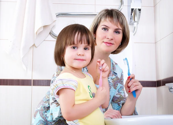Anne ve kızı dişlerini fırçalama — Stok fotoğraf