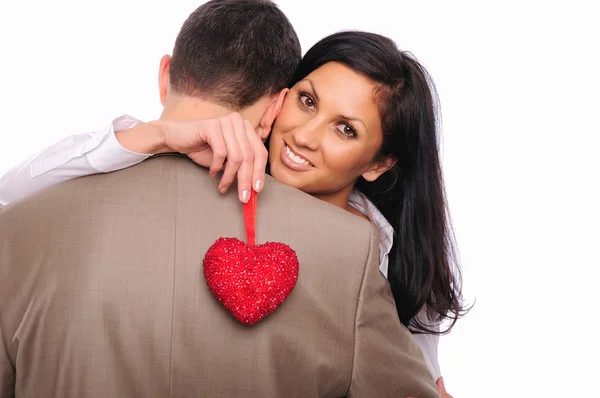 Junges Mädchen umarmt ihren Mann und hält ein rotes Herz — Stockfoto