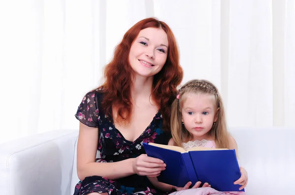 Kis lány és az anyja olvasni egy könyvet — Stock Fotó