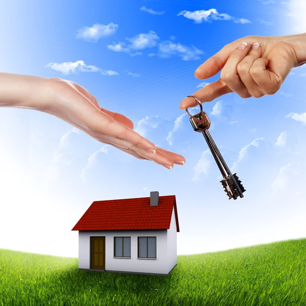 House in the hands against the blue sky — Stock Photo, Image