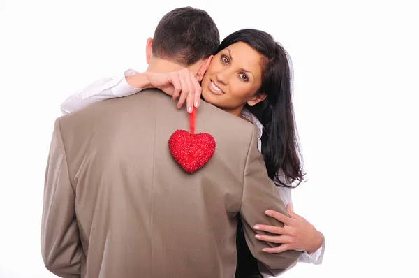 Menina abraça seu homem e segurando um coração vermelho — Fotografia de Stock