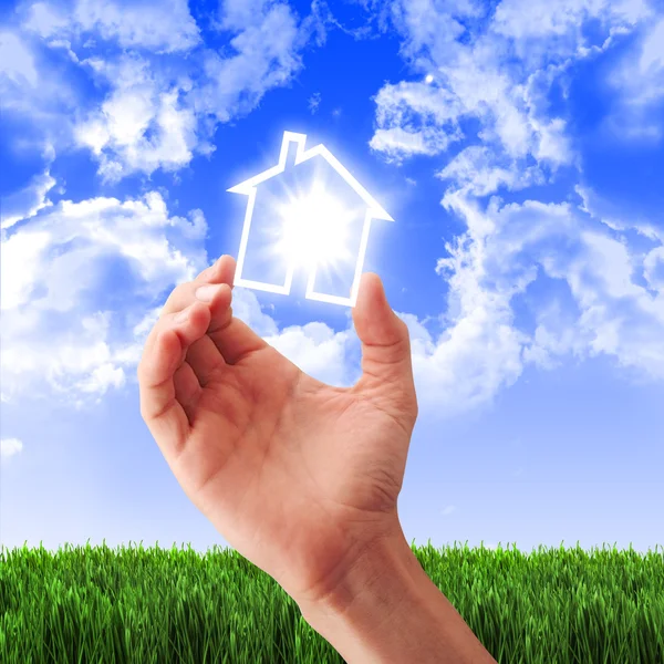 Dům v rukou proti modré obloze — Stock fotografie