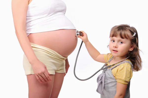 Ittle girl listens to a stethoscope belly — Stock Photo, Image