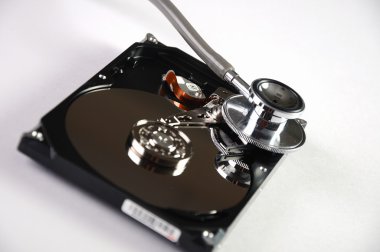 Computer hard drive and a stethoscope. clipart