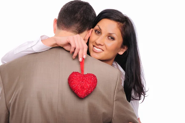 Young girl hugs her man and holding a red heart — Stock Photo, Image