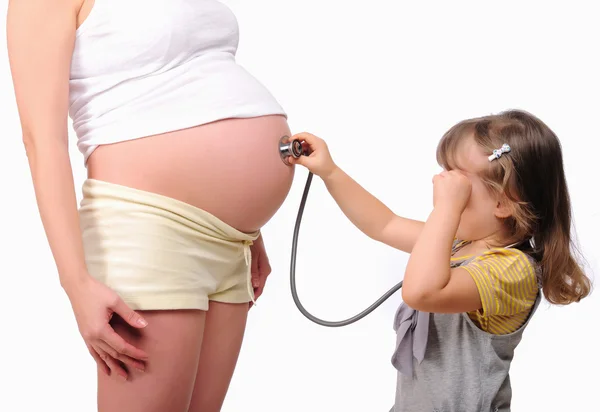 Ittle girl listens to a stethoscope belly — Stock Photo, Image