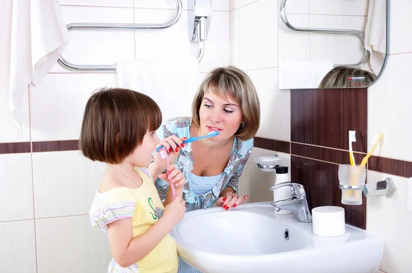 Mãe e filha escovando os dentes — Fotografia de Stock