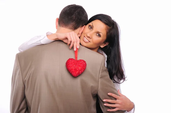 Young girl hugs her man and holding a red heart — Stock Photo, Image