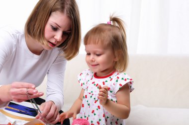 Young mother and her baby daughter clipart