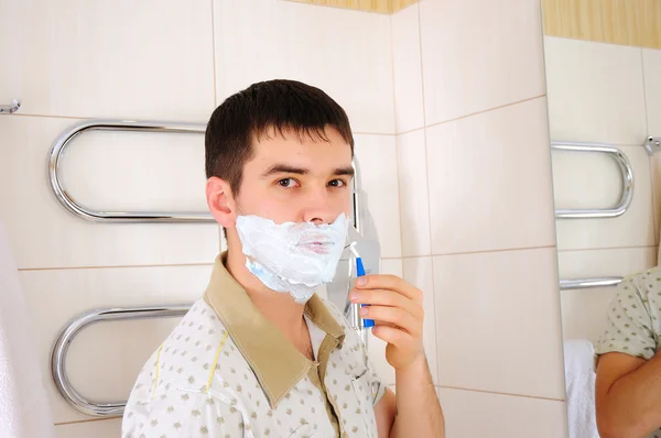 Junger Mann rasiert sich am Morgen — Stockfoto
