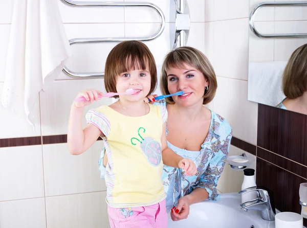 Mãe e filha escovando os dentes — Fotografia de Stock
