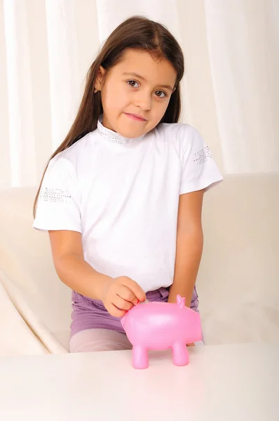 Маленькая девочка вкладывает свои сбережения — стоковое фото
