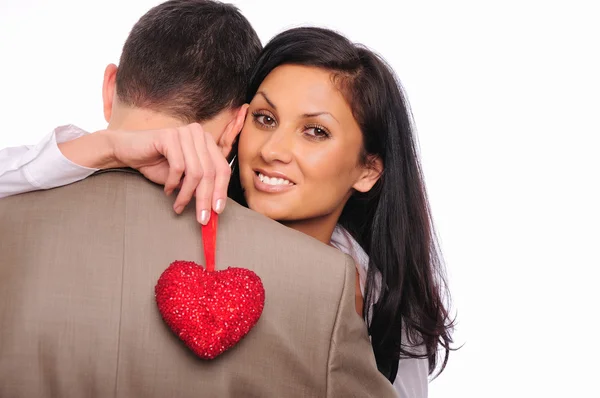 Молодая девушка обнимает своего мужчину и держит красное сердце — стоковое фото
