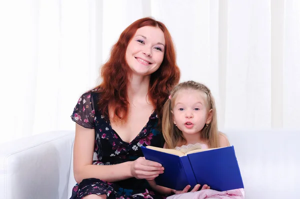 Kis lány és az anyja olvasni egy könyvet — Stock Fotó