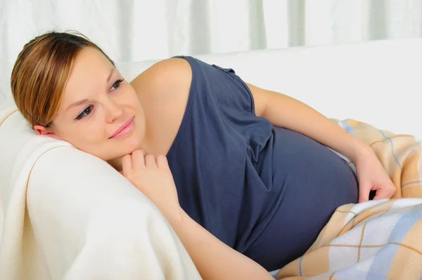 Těhotná žena ležící na pohovce — Stock fotografie