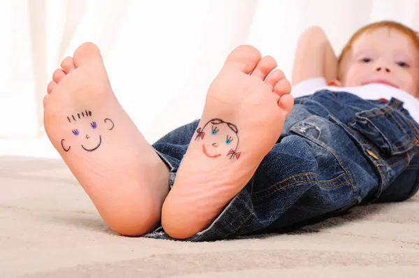 Stock image Small faces painted on the soles of a young boy