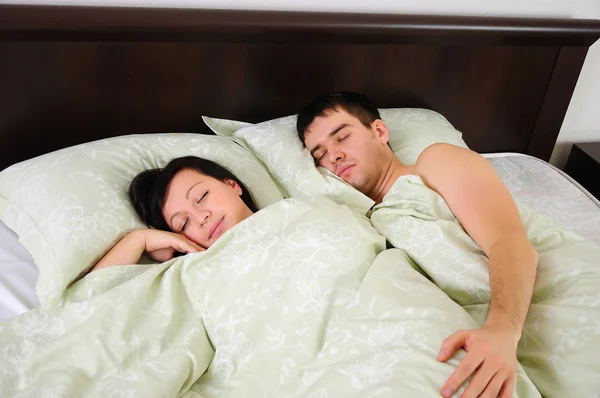 つのベッドで一緒に寝ている若いカップル ロイヤリティフリーのストック写真