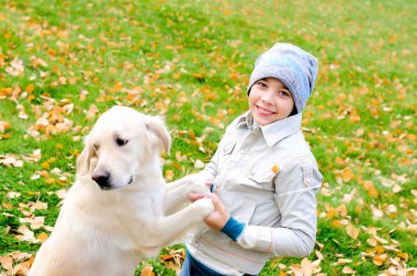 Çocuk bir golden retriever ile sonbahar Park oyun.