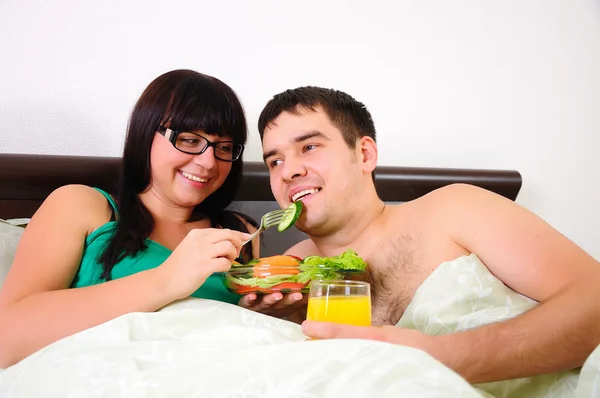 年轻的夫妇在躺在床上一起在清晨早餐 — 图库照片