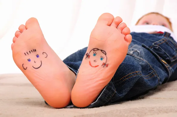 stock image Small faces painted on the soles of a young boy
