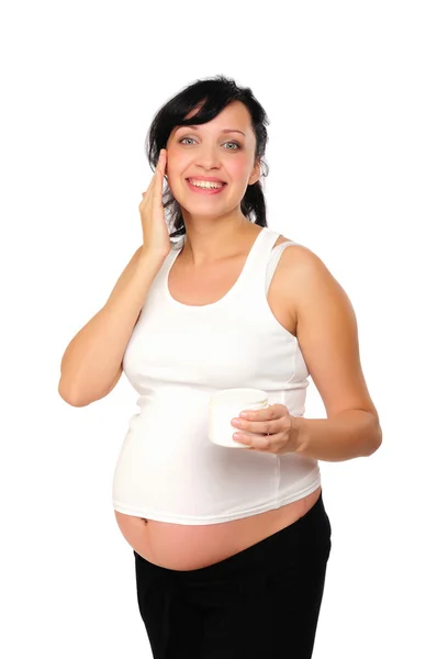 年轻怀孕的妈妈使用美容霜 — 图库照片
