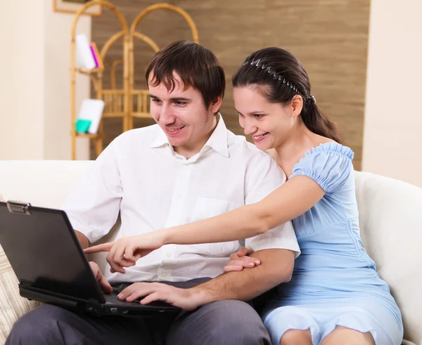 Young family at home with a laptop — Stock Photo, Image