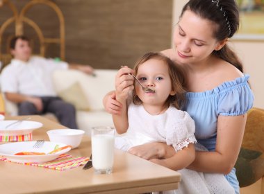 genç anne bebek evde th e mutfakta bir kaşıkla besleme