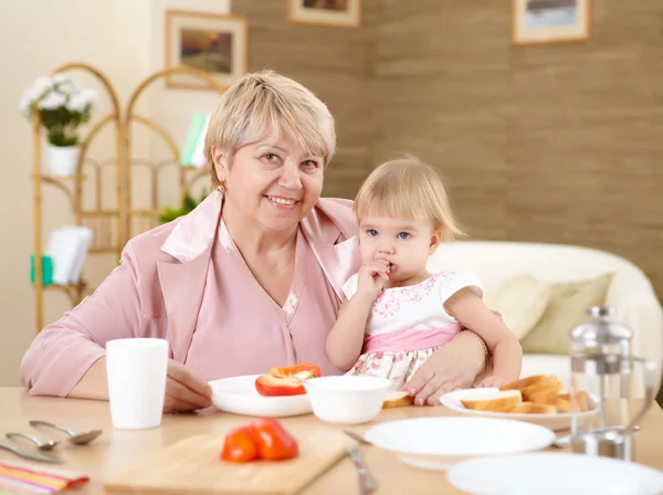 Grandmother Feeding Her Little Baby Granddaughter Home — Stock Photo, Image