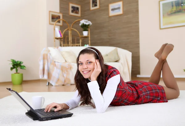 A young girl with a lap top at home — Stock Photo, Image
