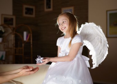 A little girl in white dress with angel's wings clipart
