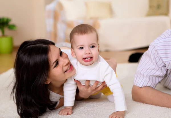 年轻幸福的家庭和一个婴儿在客厅里玩 — 图库照片