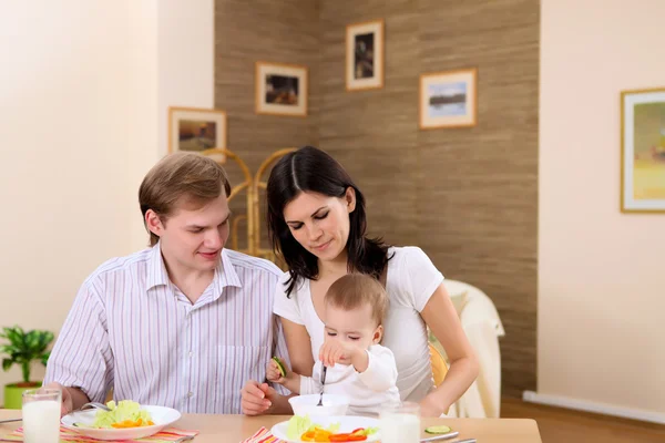 Mladá rodina doma s jídlem — Stock fotografie