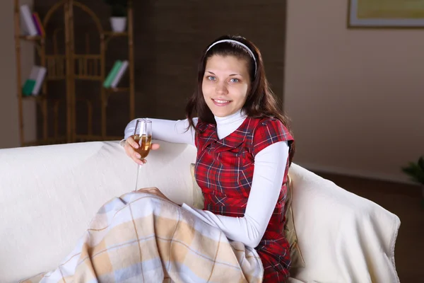 Une jeune fille avec un verre de vin à la maison — Photo