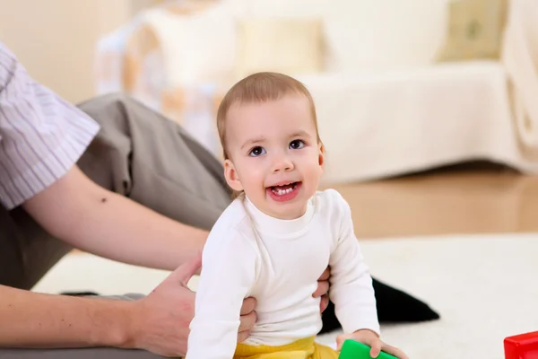 Jonge familie thuis spelen met een baby — Stockfoto