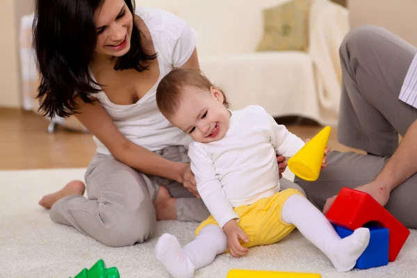 Giovane famiglia a casa a giocare con un bambino — Foto Stock