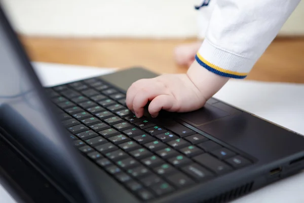 stock image Laptop on the floor with a child hand