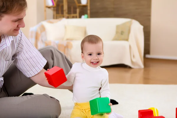 Junge Familie zu Hause spielt mit einem Baby — Stockfoto