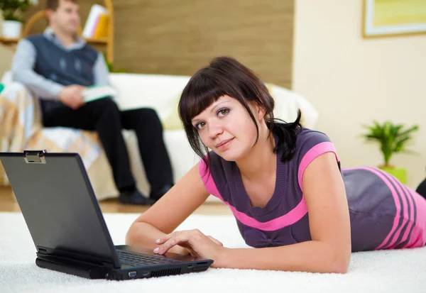 Ung kvinna med en bärbar dator hemma — Stockfoto