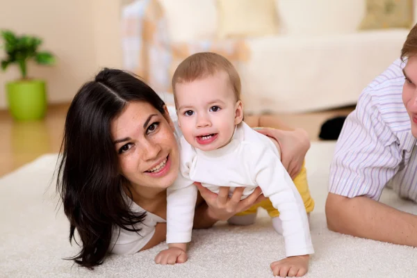 Jovem família em casa brincando com um bebê — Fotografia de Stock