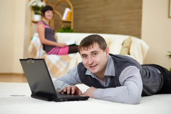 Молодой человек с ноутбуком дома — стоковое фото