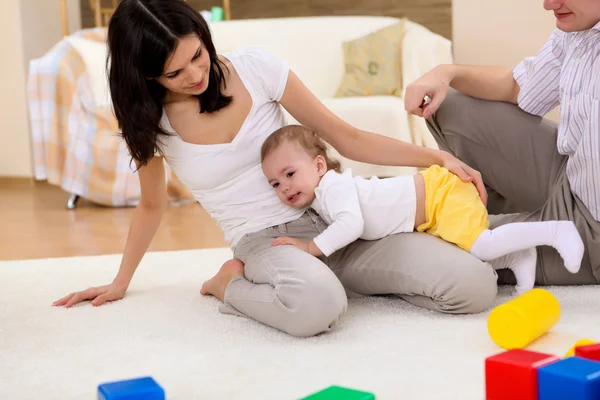 年轻幸福的家庭和一个婴儿在客厅里玩 — 图库照片