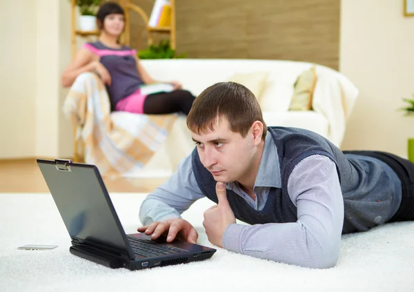 Giovane con un computer portatile a casa — Foto Stock