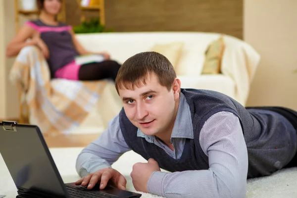 Νεαρός άνδρας με ένα φορητό υπολογιστή στο σπίτι — Φωτογραφία Αρχείου