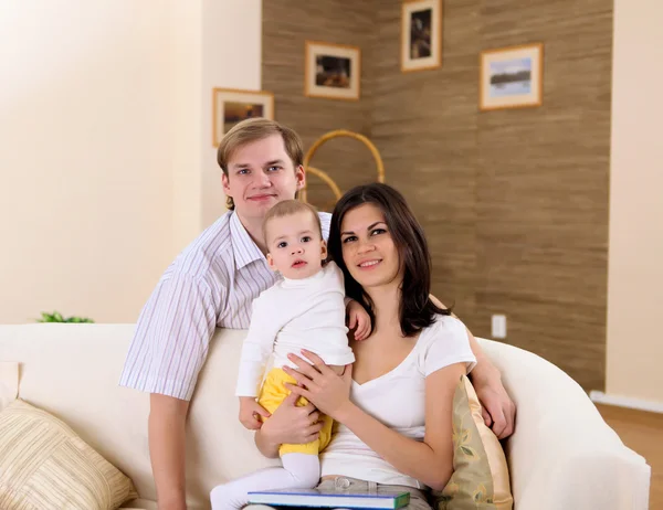 Familia joven en casa jugando con un bebé —  Fotos de Stock