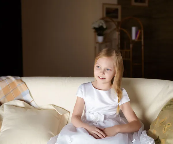 Ein Schönes Kleines Mädchen Weißem Kleid Sitzt Auf Einem Sofa — Stockfoto
