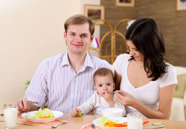 Young family at home having meal — Stock Photo, Image