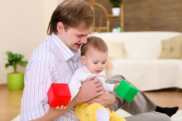 Jovem família em casa brincando com um bebê — Fotografia de Stock