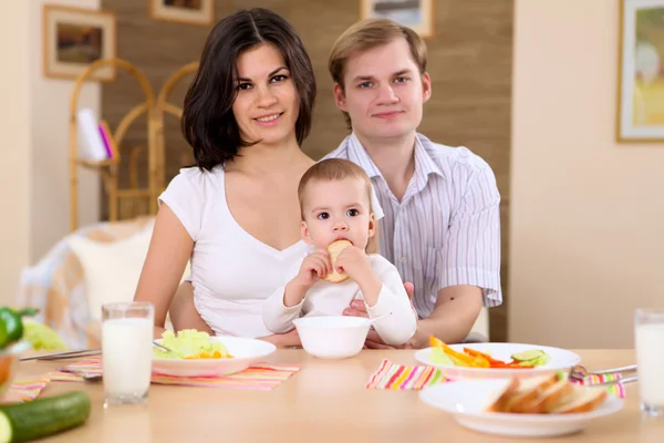 Mladá rodina doma s jídlem — Stock fotografie