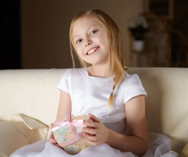 Красивая Маленькая Девочка Белом Платье Сидит Диване Подарком Дома — стоковое фото
