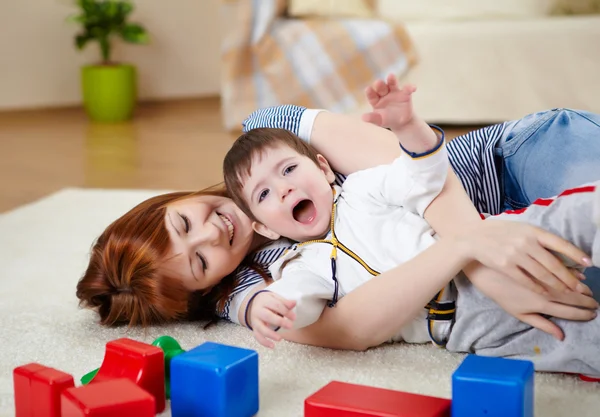 Junge Mutter spielt mit ihrem kleinen Sohn — Stockfoto